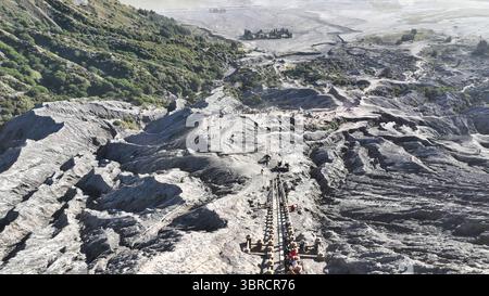 En regardant vers le bas depuis le volcan, vous apercevez un chemin sinueux et un escalier menant les aventuriers à travers un paysage accidenté et d'un autre monde vers un TEM lointain Banque D'Images