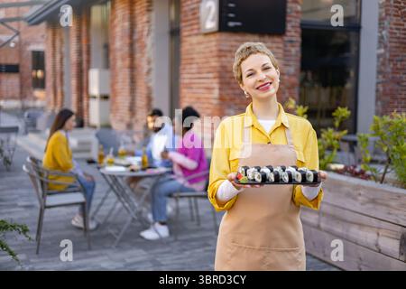 Serveuse de sushi au service des clients Banque D'Images