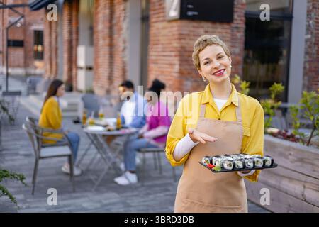 Serveuse avec sushi au restaurant Banque D'Images