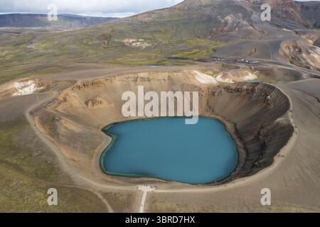 Vue aérienne des eaux turquoises du lac de cratère Víti niché dans le paysage accidenté et volcanique de la caldera de Krafla, Fosshóll, Þingeyjarsveit, Islande. Banque D'Images