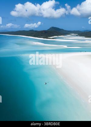 Vue aérienne du sable blanc et des eaux turquoises, créant des motifs fascinants avec pour toile de fond les îles luxuriantes du Queensland, Australie. Banque D'Images