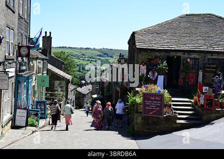 Shoppers sur Haworth main Street, soleil d'été, Bronte Country, West Yorkshire. Banque D'Images