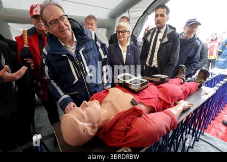 Rostock, Allemagne. 12 juillet 2025. Alexander Dobrindt (CSU), ministre fédéral de l'intérieur, a fait une démonstration des soins aux blessés lors d'une visite de la Journée nationale de la protection civile dans le port de la ville hanséatique. Environ 40 acteurs des secteurs de l’incendie, de la protection civile et de la lutte contre les catastrophes fournissent des informations sur leur travail. Rostock est la troisième ville après Potsdam et Wiesbaden à accueillir la journée, qui a cette fois pour devise « L'eau - utiliser les ressources, maîtriser les risques ». Crédit : Bernd Wüstneck/dpa/Alamy Live News Banque D'Images