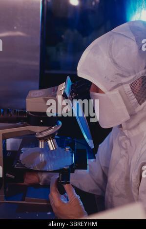 Taiwan. Industrie des composants électroniques. Technicien vérifiant le semi-conducteur avec un microscope. Banque D'Images
