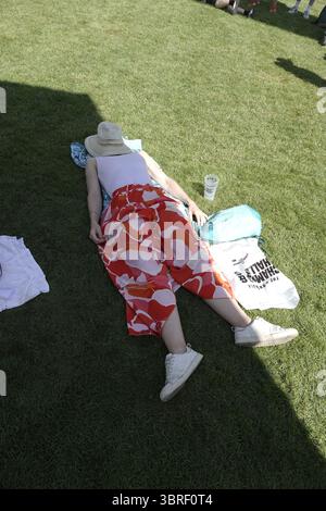 Goodwood, West Sussex, Royaume-Uni. 12 juillet 2025. Spectateur épuisé à l'extérieur de Goodwood House s'abri du soleil dans des conditions de canicule, au Goodwood Festival of Speed (FOS) qui s'est tenu sur le domaine Duke of RichmondÕs. Crédit : Motofoto/Alamy Live News Banque D'Images