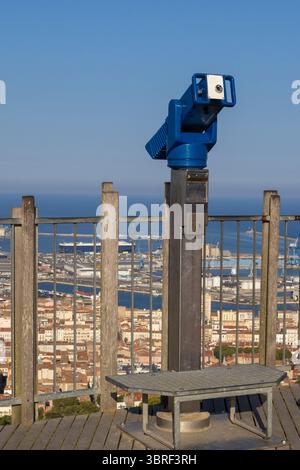 Jumelles bleues à pièces de monnaie offrant une vue sur le port et la ville de sète, en france, par une journée ensoleillée avec un ciel bleu clair Banque D'Images
