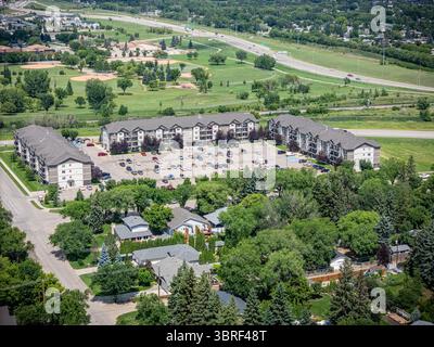 Quartier résidentiel avec beaucoup de maisons et un grand parking. Les maisons sont toutes de tailles et de styles différents, et le parking est rempli de voitures. Banque D'Images