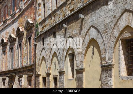 061 arcs pointus et fenêtres à fronton sur les façades des bâtiments médiévaux et Renaissance sur la rue via Ricci côté est. Montepulciano-Toscane-Italie. Banque D'Images