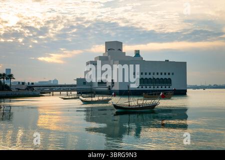 Musée d'art islamique à Doha, Qatar au coucher du soleil. Architecture moderne éclairée par la lumière chaude du soir, reflétée dans les eaux calmes du front de mer. Paisible a Banque D'Images