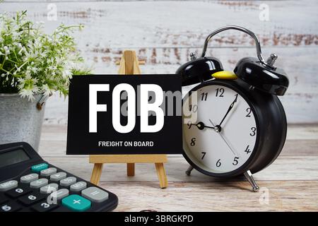 FOB Freight sur le texte de bord avec réveil et calculatrice sur fond en bois Banque D'Images