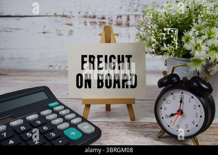 FOB Freight sur le texte de bord avec réveil et calculatrice sur fond en bois Banque D'Images