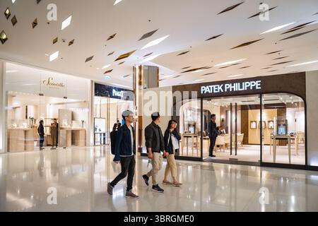 Bangkok, Thaïlande. 12 juillet 2025. Les acheteurs passent devant des boutiques de montres de luxe, dont Patek Philippe. Logos de marque et vitrines à l'intérieur des zones de luxe, de beauté, de divertissement et de restauration de Siam Paragon, l'un des centres commerciaux les plus haut de gamme de Bangkok. Les images illustrent comment le branding visuel définit l'espace commercial contemporain. Crédit : SOPA images Limited/Alamy Live News Banque D'Images
