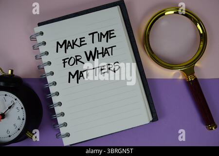 Préparez le texte Time for What Matters écrit sur du papier portable avec une loupe et un réveil Banque D'Images