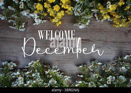 Texte de bienvenue de décembre avec cadre de fleurs sur fond en bois Banque D'Images