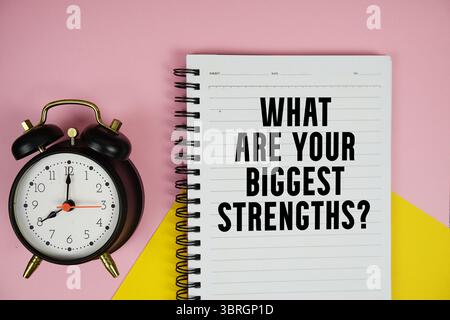 Quelles sont vos plus grandes forces ? texte écrit sur le bloc-notes avec réveil sur fond rose Banque D'Images