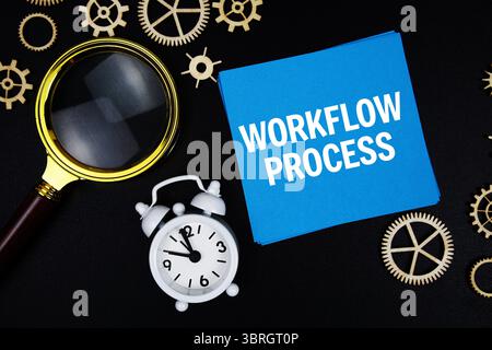 Flux de travail processus message texte sur note adhésive avec loupe et réveil sur fond noir Banque D'Images