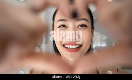 Femme asiatique montrant pour caméra geste en forme de cœur, gros plan Banque D'Images