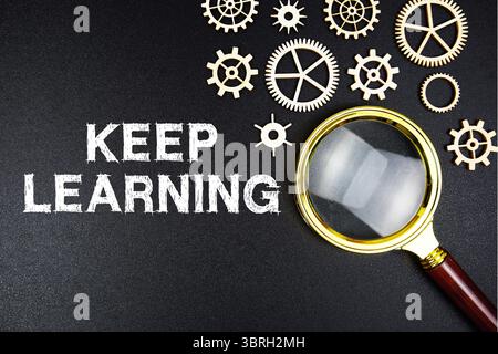 Continuez à apprendre un message texte avec une loupe sur fond noir Banque D'Images