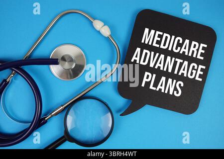 Texte Medicare Advantage plans avec stéthoscope et loupe sur fond bleu Banque D'Images