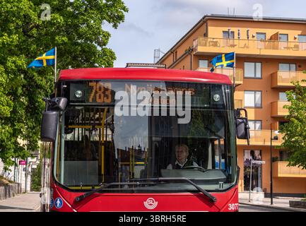 Sodertalje, Suède - 6 juin 2025 : un bus rouge affichant le numéro de ligne 718, avec un panneau de destination indiquant 'Nynäshamn Station'. Le bus est garé n Banque D'Images