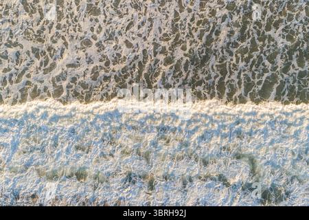 vue aérienne de haut en bas d'une puissante vague océanique s'écrasant dans de la mousse blanche, vue zénithal par drone Banque D'Images