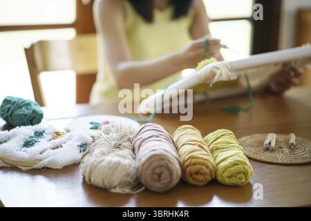 Aiguille perforée. Femme asiatique faisant tricoter Hobby à la main dans l'atelier de studio. Designer Workplace projet artisanal fait à la main concept de broderie DIY Banque D'Images