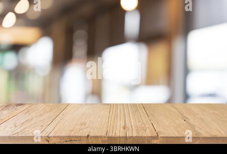Maquette d'espace. Table en bois sombre vide devant le fond abstrait flou bokeh du restaurant. peut être utilisé pour l'affichage ou le montage de votre produ Banque D'Images