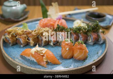 Combiné de différents sushis japonais sur une élégante assiette bleue Banque D'Images