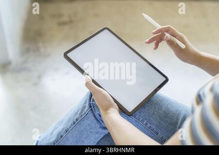 Femme tenant l'écran blanc sur le dispositif de tablette numérique. tablette de fond de technologie avec écran vide vierge Banque D'Images
