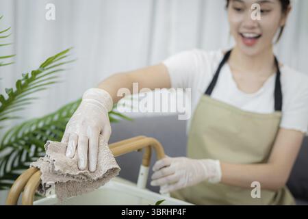 Femme de maison attrayante femme asiatique. belle femme réussie nettoyant le salon Banque D'Images