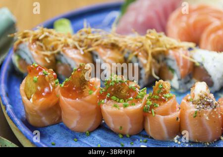 Combiné de différents sushis japonais sur une élégante assiette bleue Banque D'Images