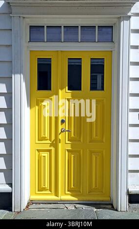 Porte d'entrée en bois jaune dans une maison blanche en claquette dans le vieux quartier historique de Gamle Stavanger, Norvège Banque D'Images