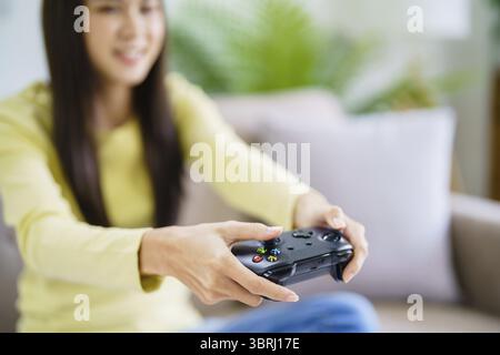 Jeune femme asiatique gamer contrôleur console vidéo jouant hobby jouant jouant jouant jouant jeu vidéo en ligne plaisir eSport Cyber Games Internet Banque D'Images