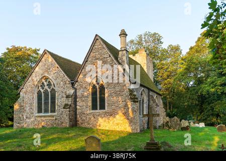 Église du 13ème siècle de St Augustine au village Kent, Snave à l'heure dorée tôt le matin. Vue extérieure, fenêtres de choir et cheminée. Banque D'Images
