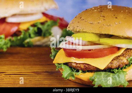 Hamburgers juteux faits maison sur fond en bois. Gros plan Banque D'Images