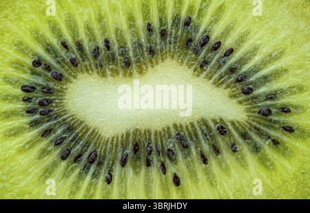 Vue de dessus gros plan de chair de kiwi vert frais mûr avec des graines noires sur un format horizontal plein cadre Banque D'Images