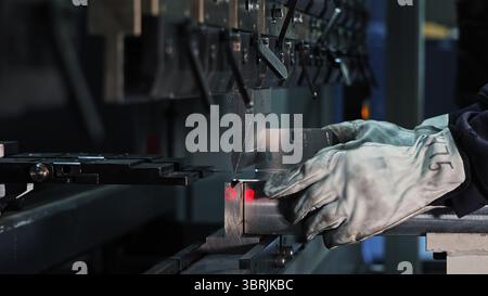 Ouvrier opérant machine de presse à CNC. Gros plan d'un ouvrier utilisant une presse plieuse CNC pour plier la tôle dans une fabrication de précision ou industrielle Banque D'Images