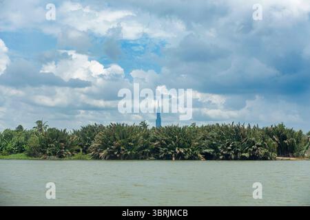 Le bâtiment Landmark 81 à Ho Chi Minh-ville se distingue au-dessus de la canopée de la forêt de noix de coco le long de la rivière Saigon à Linh Dong, Thu Duc City. Banque D'Images