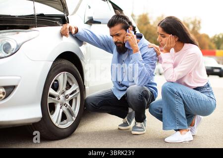 Homme indien appelant à l'aide tandis que la femme le soutient près de la crevaison Banque D'Images