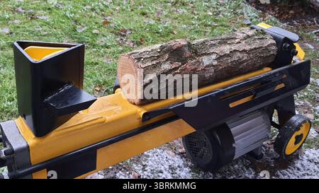 Machine à fendre les bûches se préparant à fendre le bois de chauffage à l'extérieur Banque D'Images