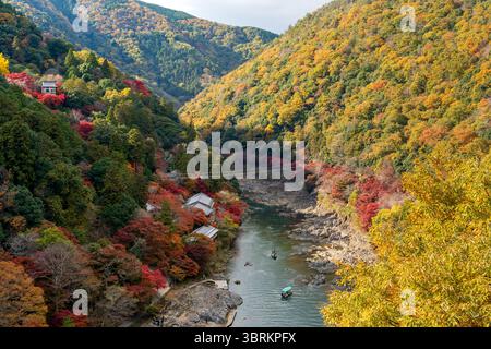 Vue aérienne des bateaux d'excursion sur la rivière Oi et la rivière Katsura dans la gorge d'Arashiyama Rankyo, un paysage d'automne époustouflant. Kyoto, Japon. Banque D'Images