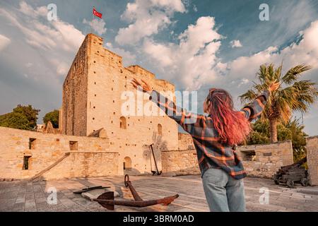 Jeune femme aux bras ouverts jouissant de la liberté devant un ancien château avec drapeau turc agitant en arrière-plan Banque D'Images