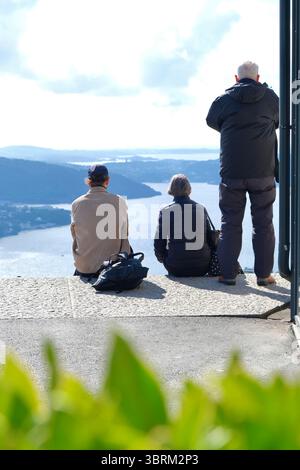 Les habitants et les touristes apprécient la vue sur la mer et la ville sur la ville côtière norvégienne Bergen au soleil du mont Fløien Banque D'Images