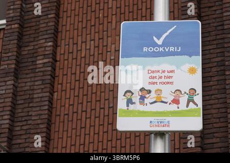 Panneau néerlandais non-fumeur avec illustration joyeuse des enfants, favorisant un environnement sans fumée près des écoles ou des terrains de jeux, contre un mur de briques dos Banque D'Images