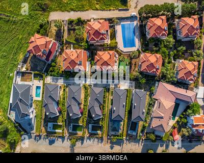 Vue drone d'un quartier résidentiel avec villas de luxe, piscines et jardins, représentant la vie moderne de banlieue Banque D'Images