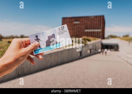5 mai 2025, Canakkale, Turkiye : main tenant un billet pour le musée de Troie, placé devant l'entrée, capturant un moment de voyage Banque D'Images