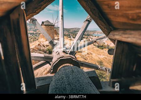 Engrenages en bois à l'intérieur d'un vieux moulin à vent surplombant la ville de Foca en Turquie par une journée ensoleillée Banque D'Images