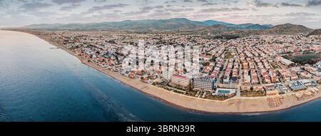 Superbe vue panoramique mettant en valeur le point de rencontre de la terre et de la mer, avec une ville côtière Dikili, Turkiye, nichée au milieu des montagnes Banque D'Images