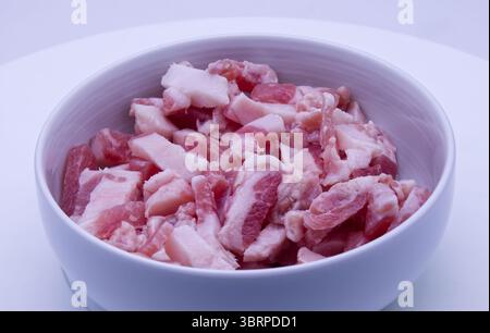 Guanciale séchée, joue de porc séchée, tranchée dans un bol blanc. Banque D'Images