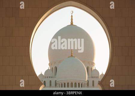 Lumière du coucher du soleil sur les dômes et les minarets de la grande mosquée Sheikh Zayed à Abu Dhabi Banque D'Images
